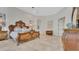 Well-lit main bedroom with travertine flooring, arched alcove and a decorative antique-styled bed at 1906 Oakbrook Dr, Longwood, FL 32779