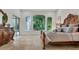 Sunlit main bedroom with travertine flooring, large windows and an antique-styled furniture set at 1906 Oakbrook Dr, Longwood, FL 32779
