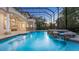 Inviting outdoor pool area enclosed by a screened lanai with a spa and scenic backyard views at 1906 Oakbrook Dr, Longwood, FL 32779