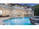 Private screened-in outdoor pool area with a stone bar, multiple seating areas and beautiful home backdrop at 1906 Oakbrook Dr, Longwood, FL 32779