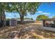Large, fenced backyard with mature trees, a storage shed, and a view of the screened porch at 1912 Wyandotte Trl, Casselberry, FL 32707