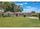 Well-maintained single-story home featuring a lush lawn, a two-car garage, and mature trees on a sunny day at 1912 Wyandotte Trl, Casselberry, FL 32707