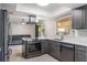 Kitchen boasts stainless steel appliances, gray cabinetry, quartz counters, tile backsplash, and center island at 1912 Wyandotte Trl, Casselberry, FL 32707