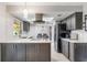 The kitchen features stainless appliances, gray cabinetry, quartz counters, and easy access to dining area at 1912 Wyandotte Trl, Casselberry, FL 32707