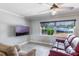 Relaxing living room featuring comfortable seating, a large window, and a ceiling fan for added comfort at 1912 Wyandotte Trl, Casselberry, FL 32707