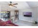 Bright living room features wood floors, modern ceiling fan, and views into dining area at 1912 Wyandotte Trl, Casselberry, FL 32707