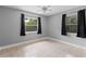 Bedroom with light gray walls, tile flooring, ample light through large windows and a ceiling fan at 207 Rose St, Auburndale, FL 33823
