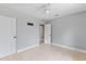 Bedroom with tile flooring, light gray walls, ceiling fan and two entry doors at 207 Rose St, Auburndale, FL 33823