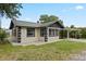 Charming single-story home with green roof, featuring a well-maintained lawn and a carport at 207 Rose St, Auburndale, FL 33823