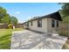 Exterior view of the home with a patio, playset in the background, siding and dark framed windows at 207 Rose St, Auburndale, FL 33823