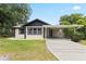 Charming single-story home with a carport, featuring a well-maintained lawn and mature trees at 207 Rose St, Auburndale, FL 33823