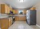 Spacious kitchen featuring wooden cabinets, stainless steel appliances, and tile backsplash at 207 Rose St, Auburndale, FL 33823