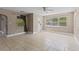 Bright living room with tile floors, ceiling fan, and natural light through large windows at 207 Rose St, Auburndale, FL 33823
