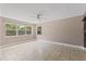 A spacious living room with tiled floors, a ceiling fan, and ample sunlight through large windows at 207 Rose St, Auburndale, FL 33823