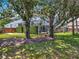 View of fenced-in backyard featuring mature trees, screened enclosure and well-maintained lawn at 2147 Whitfield Ln, Orlando, FL 32835