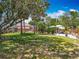 Expansive backyard featuring a manicured lawn, mature trees, patio, and an outdoor seating area at 2147 Whitfield Ln, Orlando, FL 32835