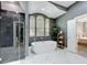 Luxurious bathroom featuring a soaking tub, glass shower, marble floors and arched windows at 2147 Whitfield Ln, Orlando, FL 32835