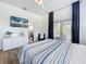 This bedroom is airy and bright and features a ceiling fan, wood floors, and curtains to block the light at 2147 Whitfield Ln, Orlando, FL 32835