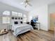 Bright bedroom features beach decor, wood floors, fan, and a unique arched window letting in plenty of natural light at 2147 Whitfield Ln, Orlando, FL 32835