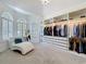 Walk-in closet with custom shelving, hanging space, and a cozy lounge area at 2147 Whitfield Ln, Orlando, FL 32835