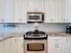 Close up of a modern kitchen with stainless steel appliances and white cabinets at 2147 Whitfield Ln, Orlando, FL 32835