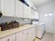The laundry room features ample storage, a utility sink, and a full-size washer and dryer set at 2147 Whitfield Ln, Orlando, FL 32835
