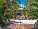 Outdoor kitchen and bar with seating surrounded by lush landscaping creates a tropical paradise at 2147 Whitfield Ln, Orlando, FL 32835