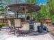 Outdoor kitchen under a gazebo including a grill, bar, and seats at 2147 Whitfield Ln, Orlando, FL 32835
