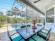 This covered patio has a dining table and chairs with a view of the pool and palm trees at 2147 Whitfield Ln, Orlando, FL 32835