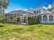 Backyard view of home with screened in pool area and landscaped yard at 2147 Whitfield Ln, Orlando, FL 32835
