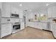 Bright kitchen featuring white cabinets, stainless steel appliances, subway tile backsplash, and tile flooring at 216 E Vanderbilt St, Orlando, FL 32804