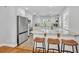 Modern kitchen with white cabinetry, stainless steel appliances, a marble countertop island, and stylish bar stools at 216 E Vanderbilt St, Orlando, FL 32804