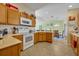 Charming kitchen with wood cabinets, white appliances, and adjacent dining area at 2192 Kerwood Loop, The Villages, FL 32162