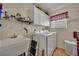 Functional laundry room featuring a utility sink, washer, dryer, and ample storage at 2192 Kerwood Loop, The Villages, FL 32162