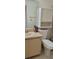 Bathroom showcasing a vanity with a sink, a large mirror, and ample storage above the toilet at 2218 Abbey Rd, Winter Haven, FL 33880