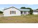 Angle view of the home's exterior with a metal roof, front yard, and sidewalk at 2314 Meadowbrook St, Kissimmee, FL 34744
