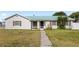 Charming single-story home featuring a green roof, manicured lawn, and decorative shutters at 2314 Meadowbrook St, Kissimmee, FL 34744