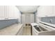 Bright laundry room featuring granite countertops, tile floors, and modern washer and dryer units at 2314 Meadowbrook St, Kissimmee, FL 34744