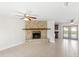 Open-concept living room with tile floors, stone fireplace, ceiling fan, and access to the pool area at 2314 Meadowbrook St, Kissimmee, FL 34744
