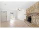 Living room featuring a stone fireplace, neutral tile flooring, and ample natural light at 2314 Meadowbrook St, Kissimmee, FL 34744