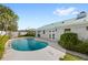 Backyard swimming pool with concrete patio, and a view of a grassy yard with tropical landscaping at 2314 Meadowbrook St, Kissimmee, FL 34744