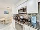 Well-equipped kitchen featuring stainless steel appliances, white cabinets, and black countertops for a modern, functional space at 232 Afton Sq # 201, Altamonte Springs, FL 32714