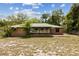 The back of the home features a lush lawn and a brick exterior with a green metal roof at 255 Katrina St, De Leon Springs, FL 32130