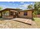 The back of the home showcases a brick exterior, wooden deck, and windows at 255 Katrina St, De Leon Springs, FL 32130