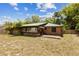 The back of the home displays a brick exterior, wood deck, and green metal roof at 255 Katrina St, De Leon Springs, FL 32130