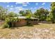 Exterior of home features green metal roof, brick, wood deck, and lush landscaping at 255 Katrina St, De Leon Springs, FL 32130