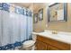 Cozy bathroom featuring a tub shower, decorative curtains, and wood cabinets at 255 Katrina St, De Leon Springs, FL 32130