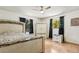 Bright bedroom featuring wood floors, a ceiling fan, and two windows with views of the trees at 255 Katrina St, De Leon Springs, FL 32130
