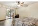 Comfortable bedroom with ceiling fan, sliding glass doors, and a view of the sunroom at 255 Katrina St, De Leon Springs, FL 32130
