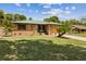 Charming brick home with a manicured lawn, an attached garage, and a green metal roof at 255 Katrina St, De Leon Springs, FL 32130